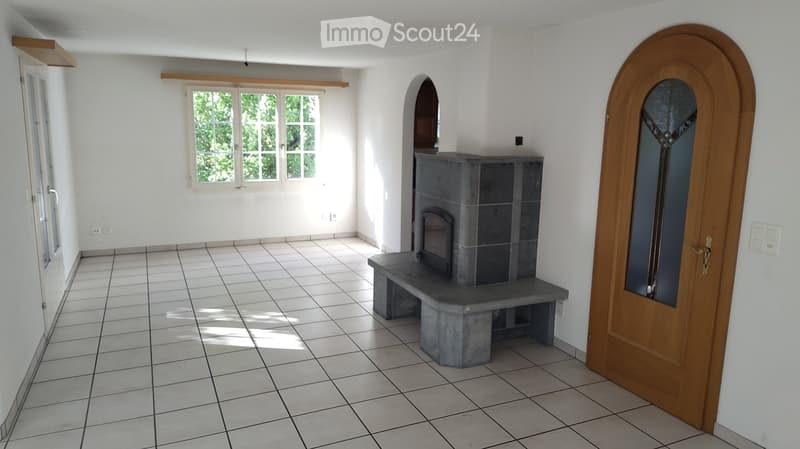 Unfurnished Room. Empty room with tiled floor, white walls, large windows, and a stone fireplace with a built-in bench.