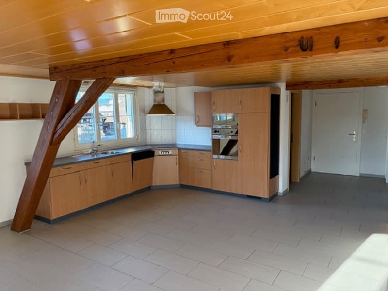 wooden cabinets, tiled floor, white countertops, stainless steel sink, oven, microwave, wooden beams, natural light