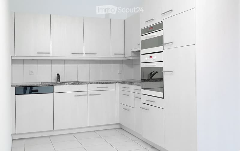 Modern kitchen with white cabinets, granite countertop, and stainless steel appliances including a dishwasher and oven.