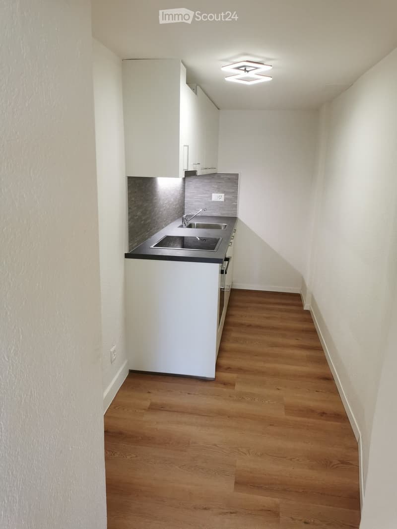 small kitchen with countertops, sink, oven and storage units