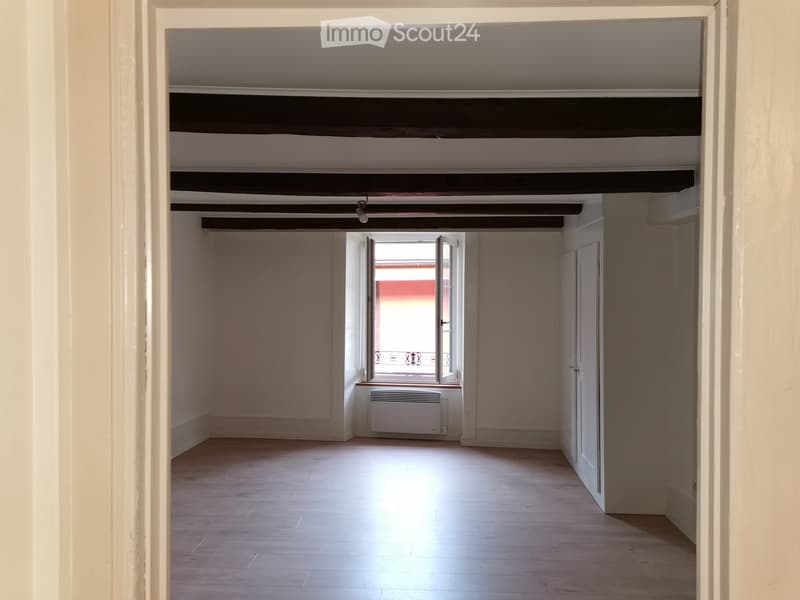 empty room, wooden floor, white walls, wooden beams, window with balcony