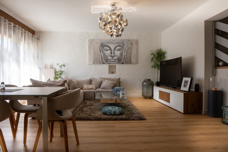 Modern living room with a sectional sofa, glass coffee table, dining table with chairs, TV stand, floor lamp, decorative vases, and artwork on the wall.