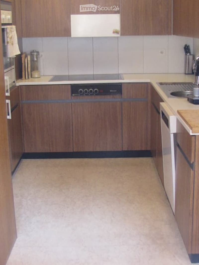 A modern kitchen with wooden cabinets, a stove, sink, and various appliances.