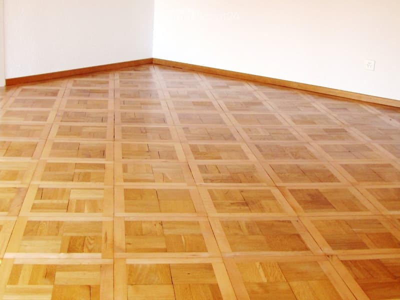 Empty room with light wooden parquet flooring and white walls. No furniture or equipment visible.