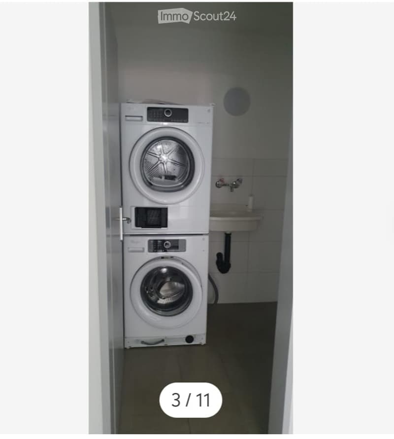 A small bathroom with a stacked washer and dryer unit and a sink.