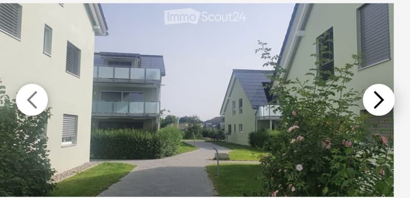 Residential complex with modern buildings, balconies, and landscaped gardens.