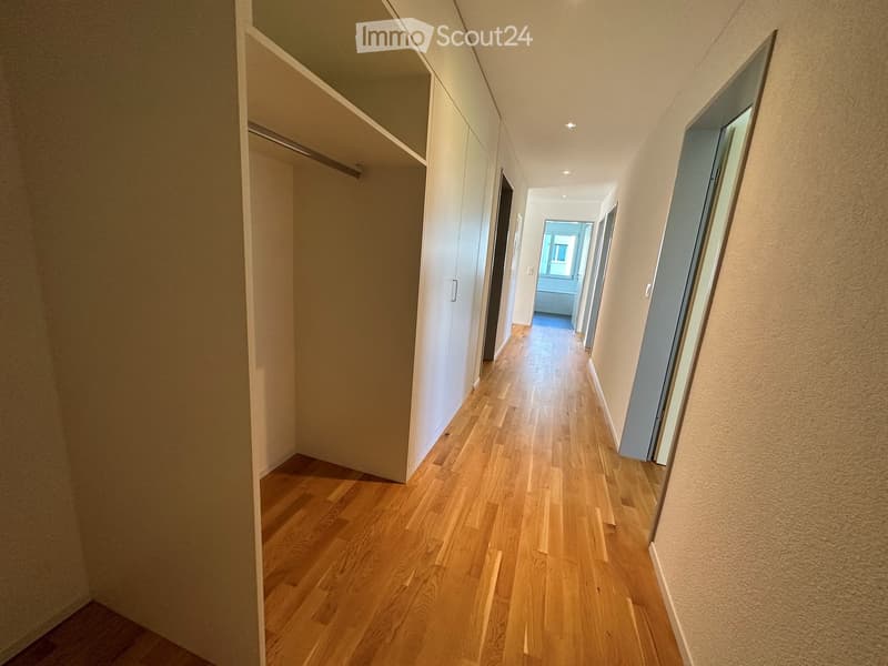 hardwood floor, white walls, 2 closets, corridor leading to rooms