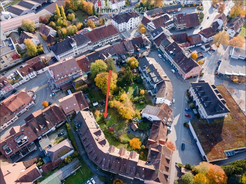 Aerial view of a residential neighborhood with multiple houses, streets, and parked cars.