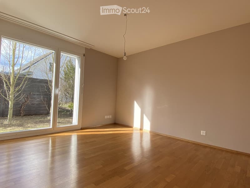 Empty room with wooden flooring, large sliding glass doors, and natural light. No furniture or equipment present.