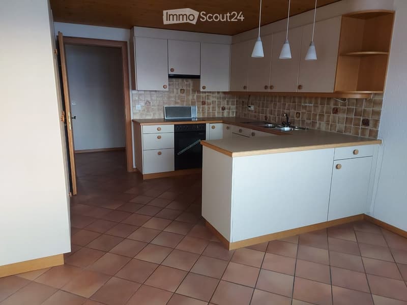 Modern kitchen with white cabinets, a central island, and a tiled backsplash. Includes a sink, faucet, oven, and microwave.