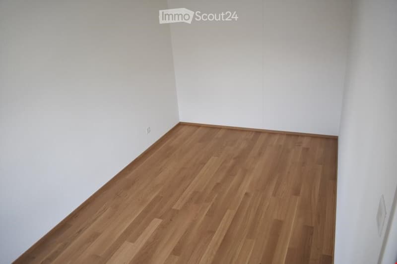 Completely empty room with bare white walls and wooden floor. No furniture or equipment.