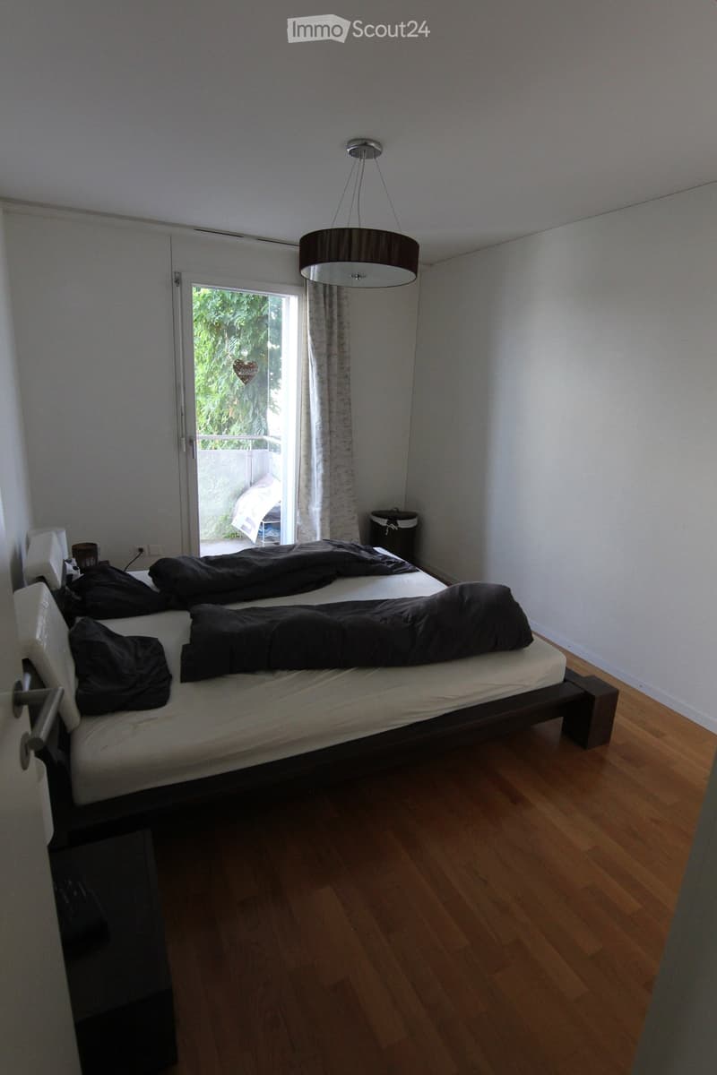 2 beds, wooden floor, glass door leading to balcony, lamp