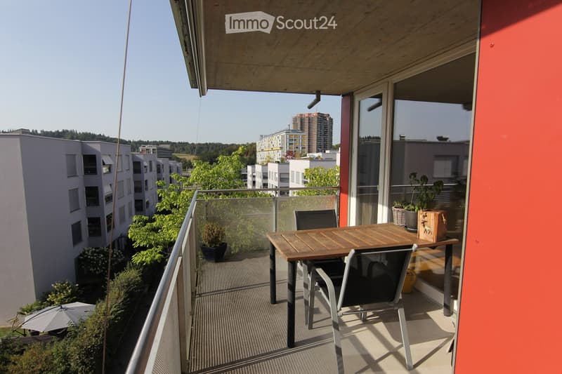 balcony with metal railing, outdoor table and chairs, view of cityscape, plants