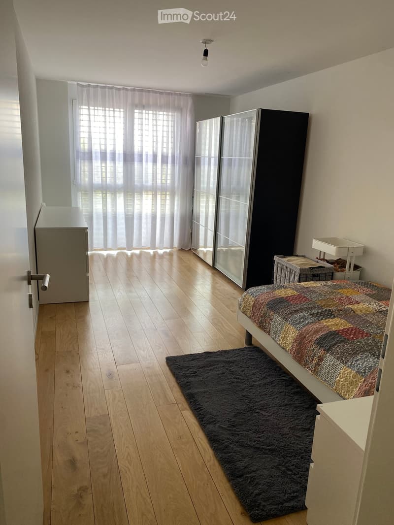 Bedroom. a simple room with a large bed, white furniture, and a rug on wooden floor