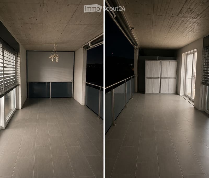 Modern, minimalist hallway with large windows, tiled floor, and a chandelier. Features a balcony area with a metal railing and sliding doors.
