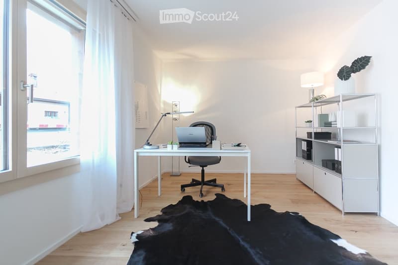 white desk, black office chair, laptop, lamp, rug, shelf, window with white curtains