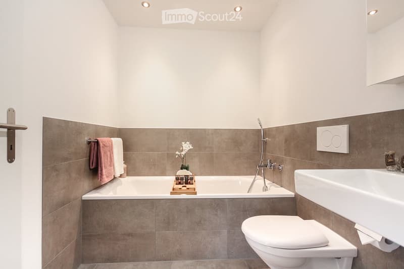 Bathroom with bathtub, toilet, sink, towel rack, and shower head