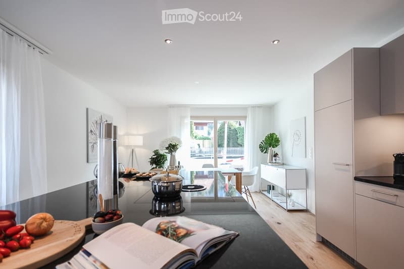 modern kitchen with island, white walls, wooden floor, large windows, dining table, plants, open book, vegetables