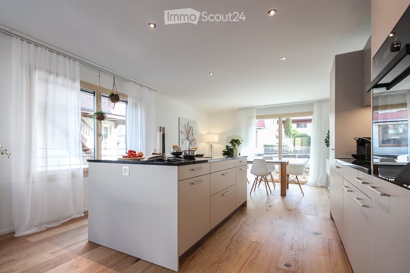 modern kitchen with island, white cabinets, wooden floor, large windows, dining area