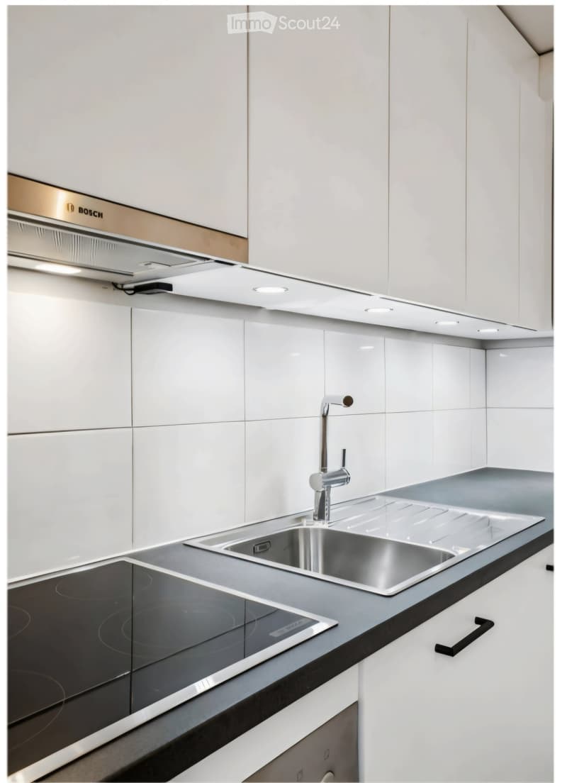 Modern kitchen with white cabinets, stainless steel sink, induction cooktop, and built-in range hood.