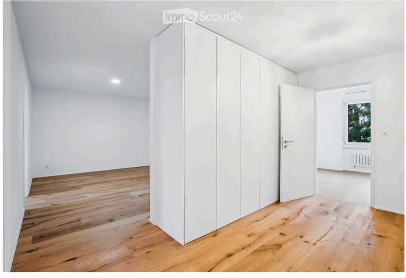 Completely empty room with white walls, wooden floor, and built-in white closet. No furniture or equipment.