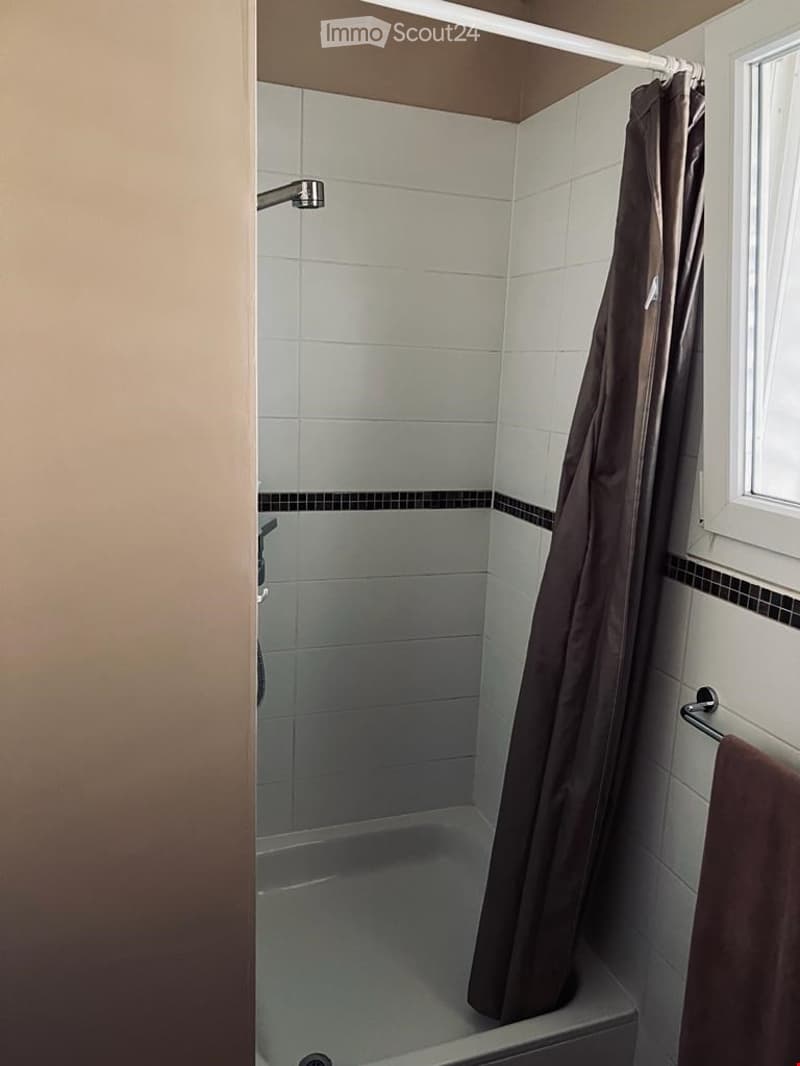 Bathroom: bathtub, shower with curtain, towel holder, tile walls and floors