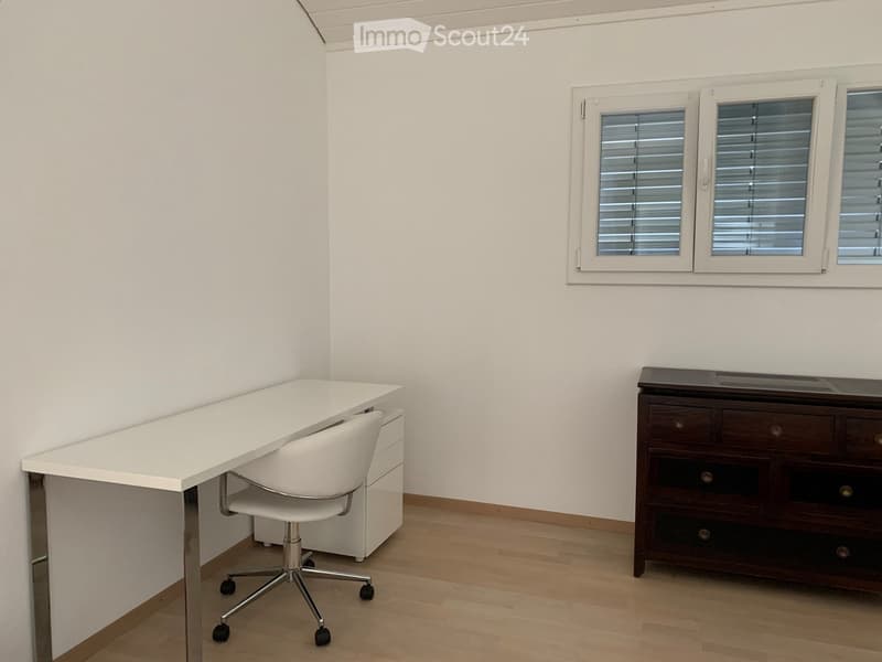 Empty office room with desk, chair, small cabinet, window with blinds