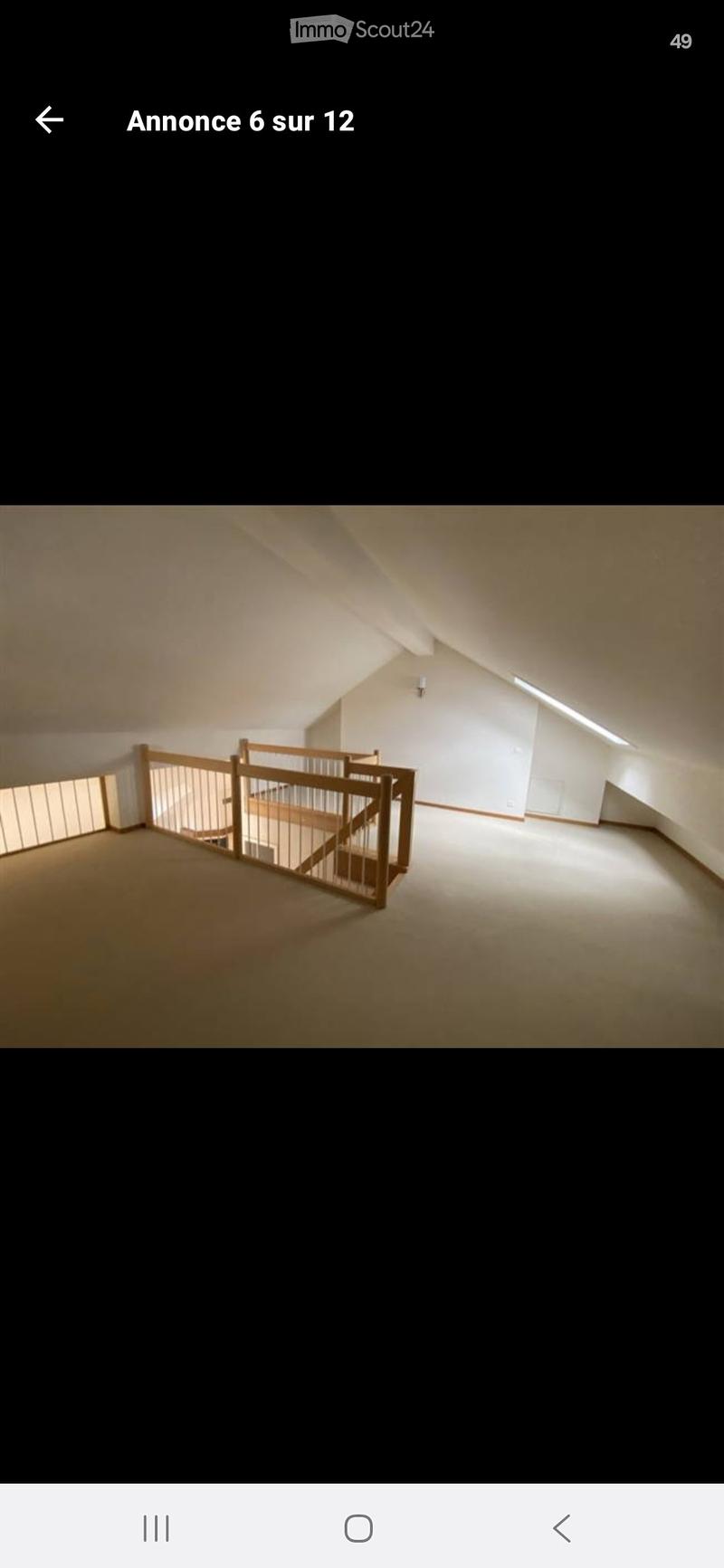 Empty attic space with wooden floor, white walls, and a staircase leading upwards, featuring exposed wooden beams on the ceiling.