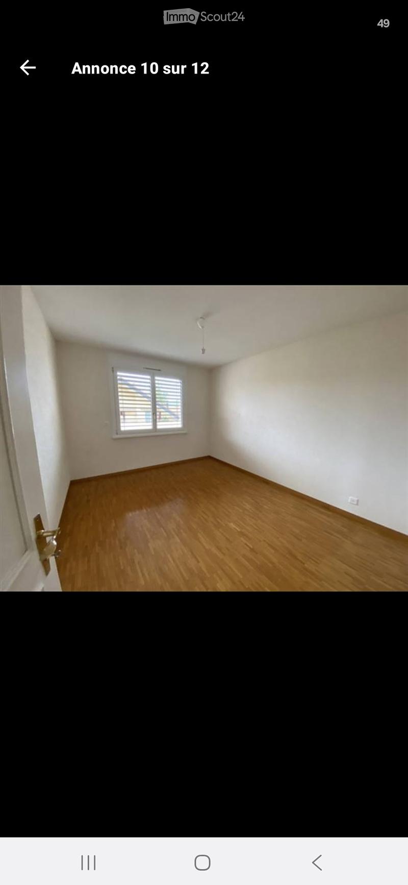 Empty room with wooden flooring, white walls, and a single window with blinds.