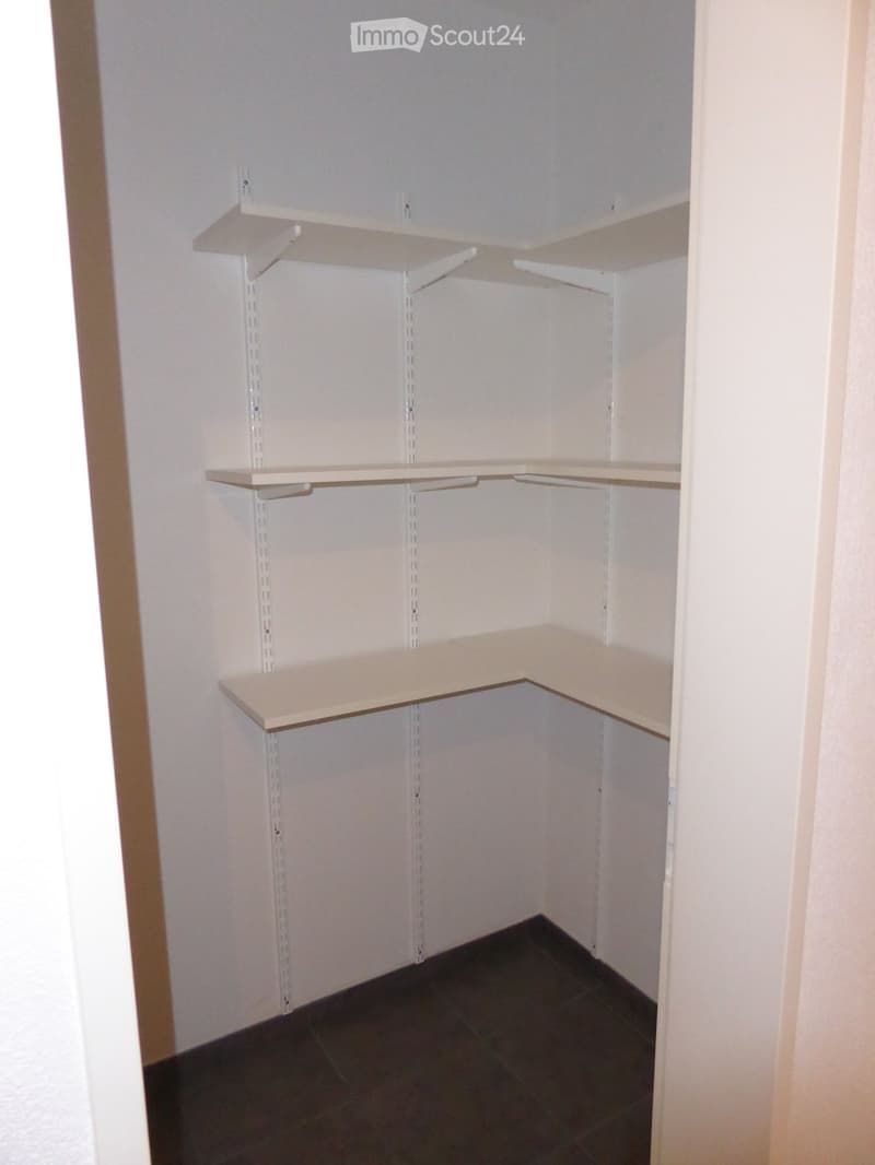 empty room with white shelves, tiled floor