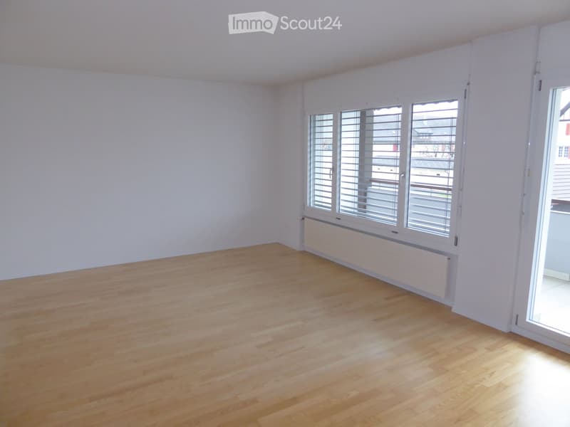 empty room, wooden floor, white walls, large window with shutters, sliding door to balcony