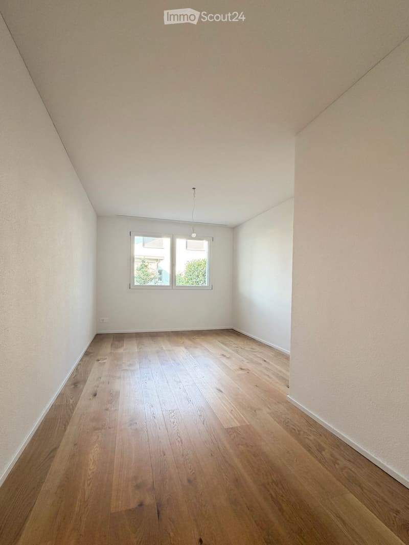 Empty room with light wooden flooring, white walls, and a window with blinds. No furniture or equipment is present.