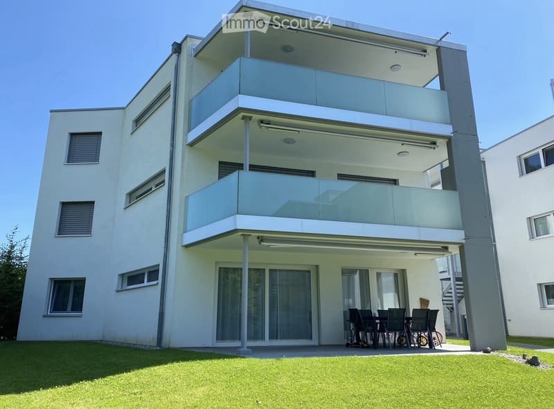 modern white building, 3 stories, multiple balconies, glass windows, outdoor dining area