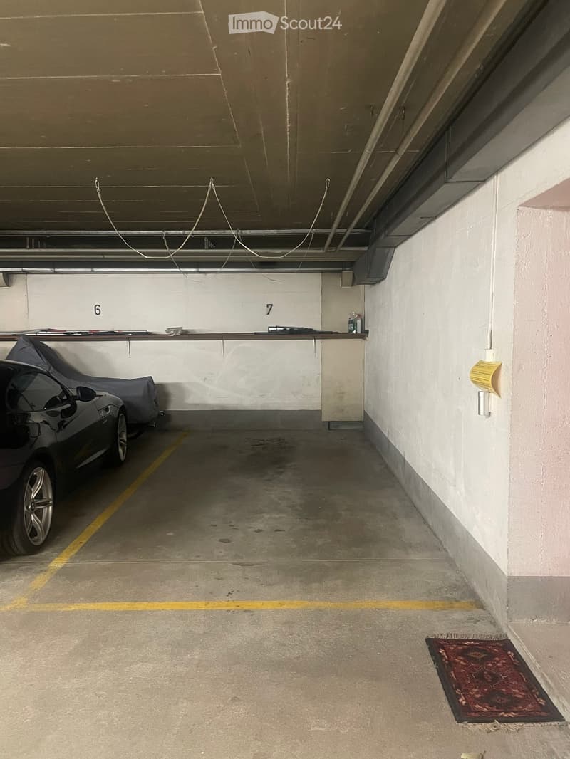 {"visible_features": ["Garage"], "type": "Garage", "objects": [], "description": "Underground parking garage with concrete floors and walls, marked parking spaces, and a covered car on the left side.", "localized_descriptions": {"EN": "Underground parking