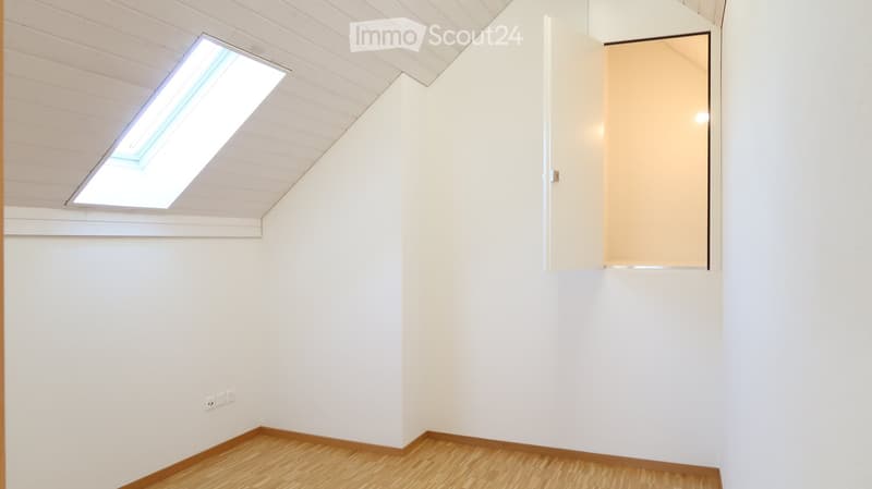 Empty room with white walls, wooden flooring, and a skylight window. No furniture or equipment present.