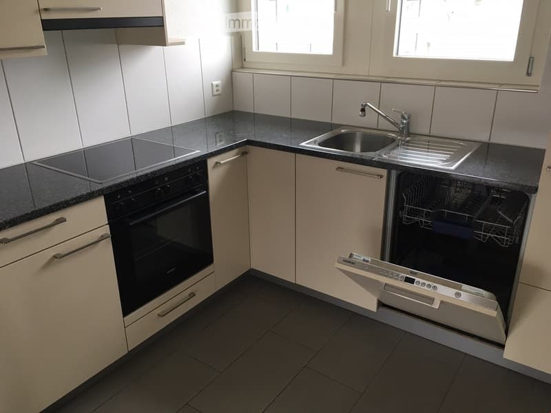 modern kitchen with black counter, electric stove, oven, dishwasher, and sink