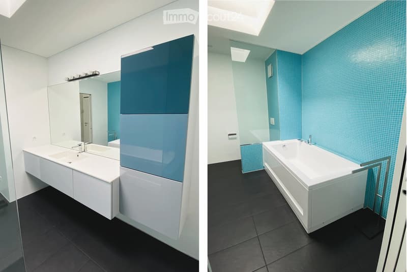Modern bathroom with white sink, mirror, and bathtub, featuring blue tiled walls and black tiled floor.