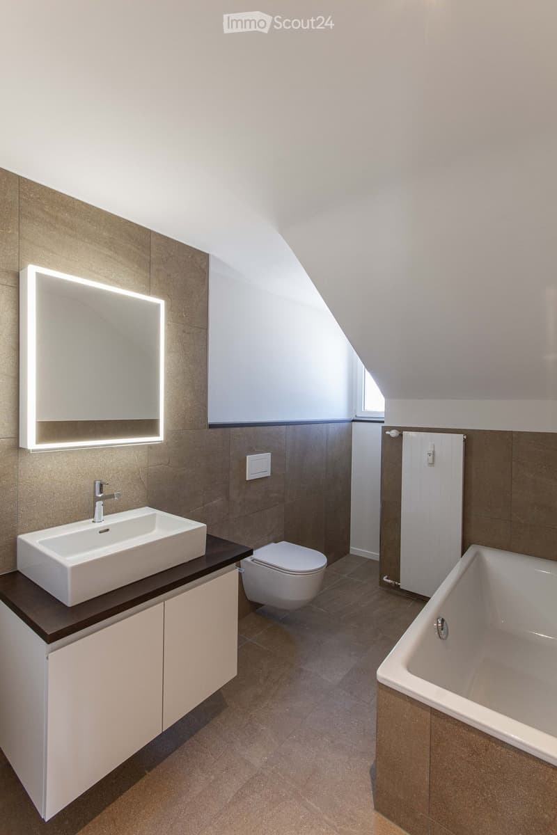modern, clean design, raised ground, white sink, white mirror, brown floor, white toilet, white bathtub, white cabinet, underfloor heating