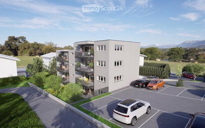 3-story residential building with balconies, surrounded by greenery and parking area.