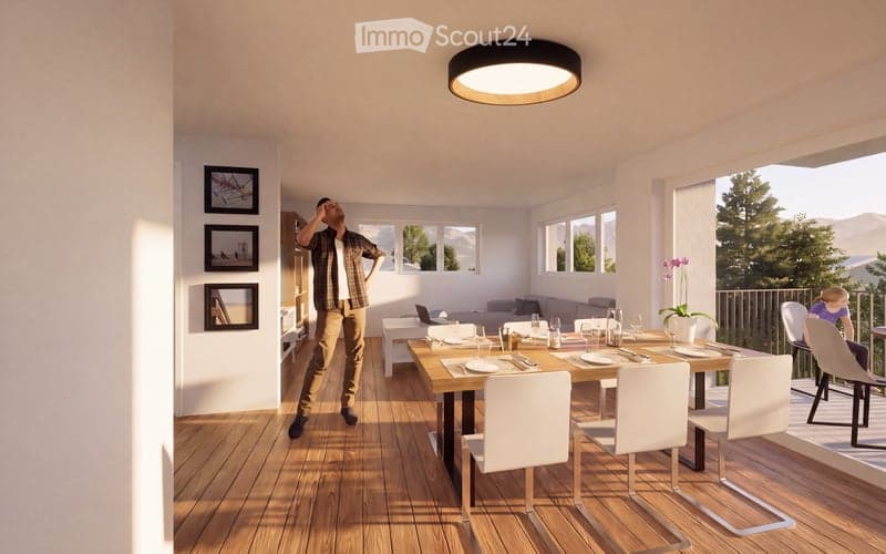 Bright dining area with wooden floor, large windows, dining table with chairs, laptop on table, sofa, and picture frames on wall.