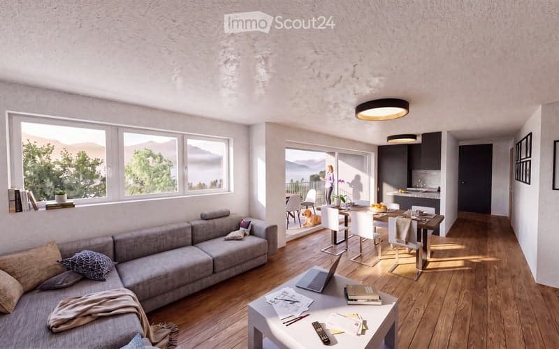 Bright, open-plan living and dining area with large windows offering a scenic view, a grey sectional sofa, a coffee table with a laptop and books, a dining table with chairs, and a modern kitchen area.