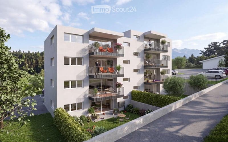 Modern multi-story residential building with balconies, surrounded by greenery and parking area.