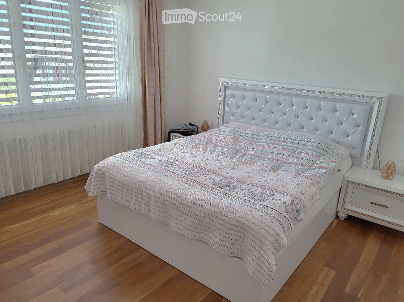 white bed, white nightstands, white curtains, wooden floor, large window