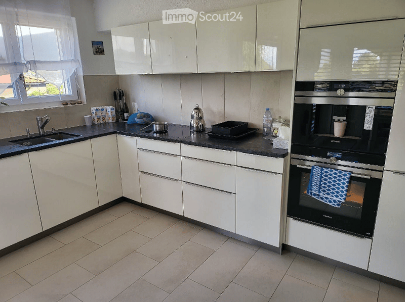 modern kitchen, white cabinets, black countertops, stainless steel appliances, tiled floor