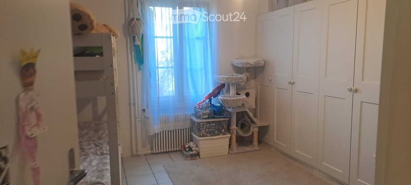 room with a window, radiator, bunk bed, and cat climbing structure