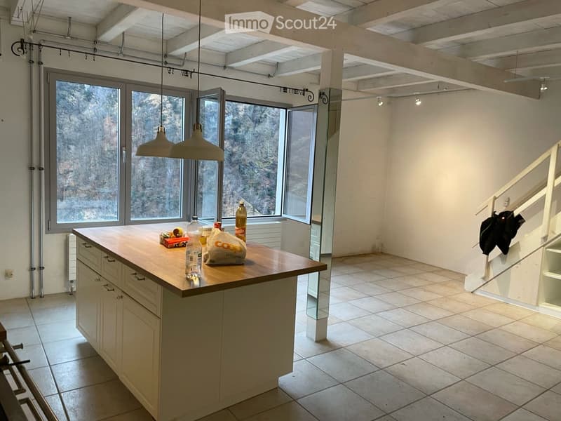 Bright kitchen with a central island, large windows, and modern lighting fixtures.