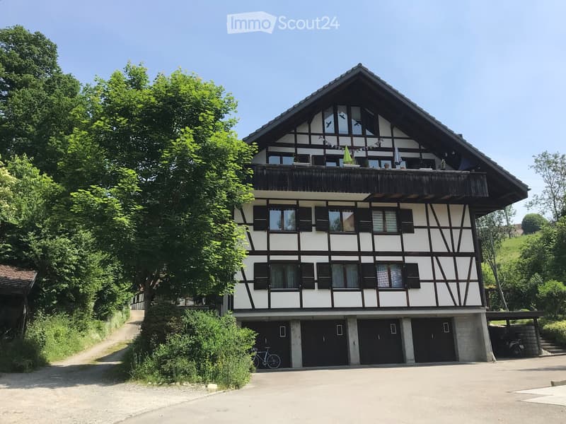 Two-story house with a balcony, garage, and traditional half-timbered facade.