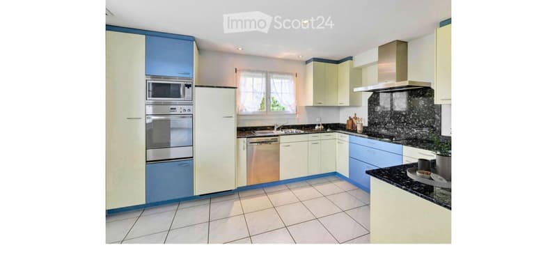 Modern kitchen with light-colored cabinets, stainless steel appliances, and a black granite countertop. Features include a refrigerator, oven, microwave, dishwasher, and a range hood.