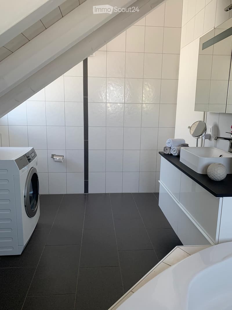 Bathroom, white tiles, black tiles, white cabinets, washing machine, bathtub, sink