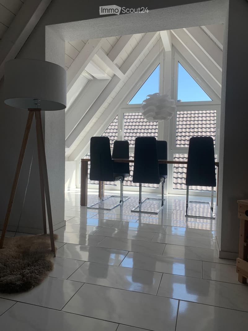 dining room, raised ground floor, large triangular window, wooden floor, dining table, chairs, lamp